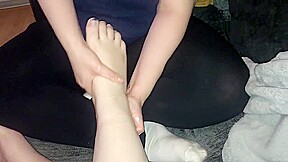 Lesbian massaging girlfriend’s feet with lotion
